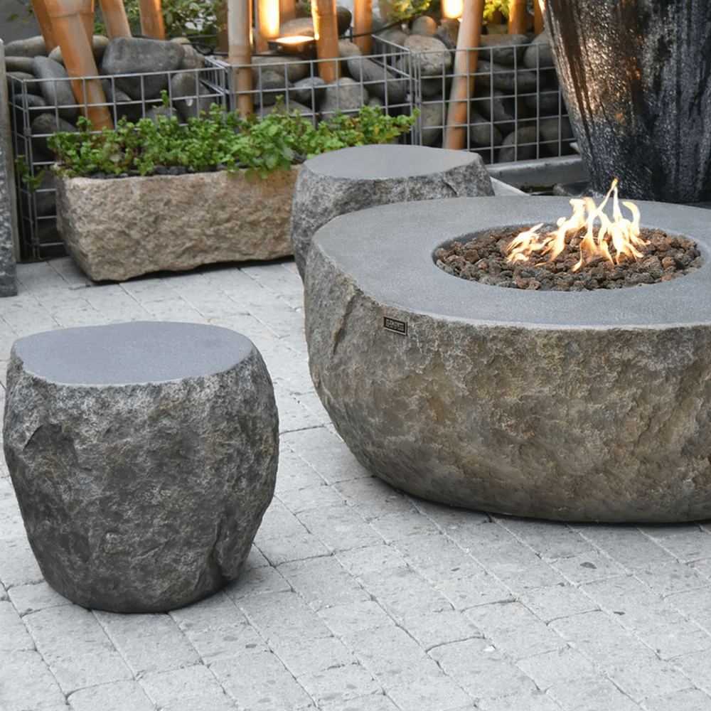 Sfeerfoto van een stenen vuurtafel met stenen krukken